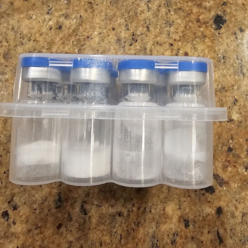 Four blue-capped vials with white solids distributed differently inside