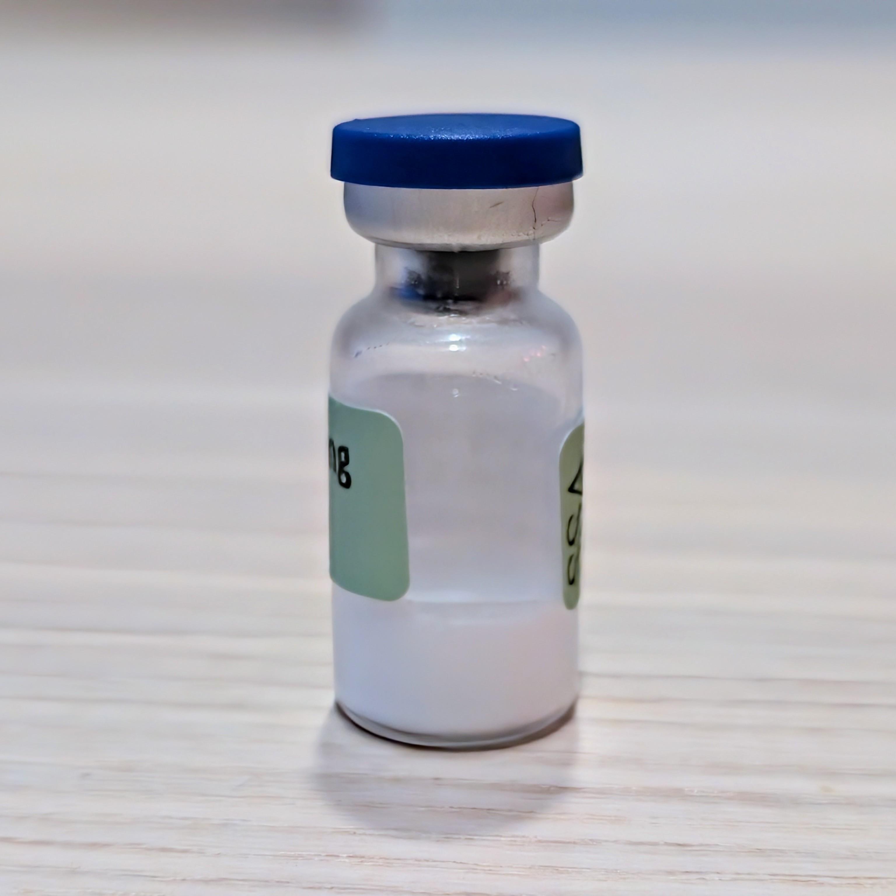 A sealed blue-capped vial with a white cake at its base