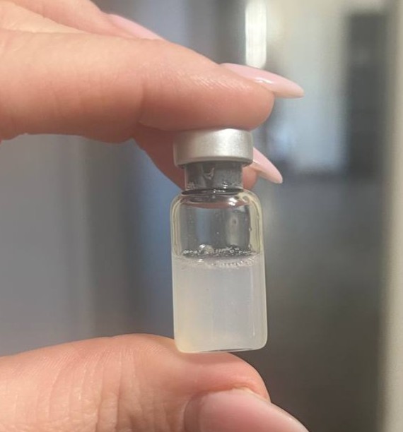 A vial containing visibly cloudy liquid